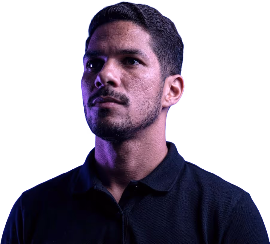 Portrait of a man with short dark hair and beard wearing a black collared shirt against a purple background.